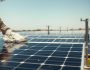 a guys hand cleaning a solar panel in the desert